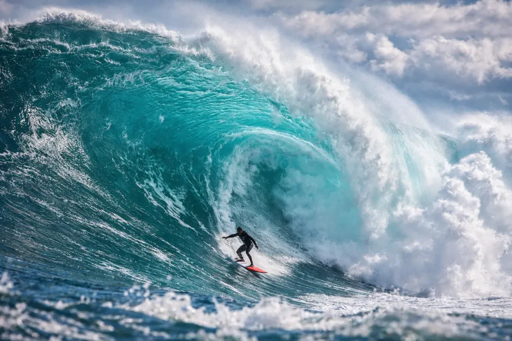 Surfeur-sur-vague-geante-a-Nazare_YBLOPTIMA.FR_-1024x682 Sports extrêmes : quand l'adrénaline rencontre la performance